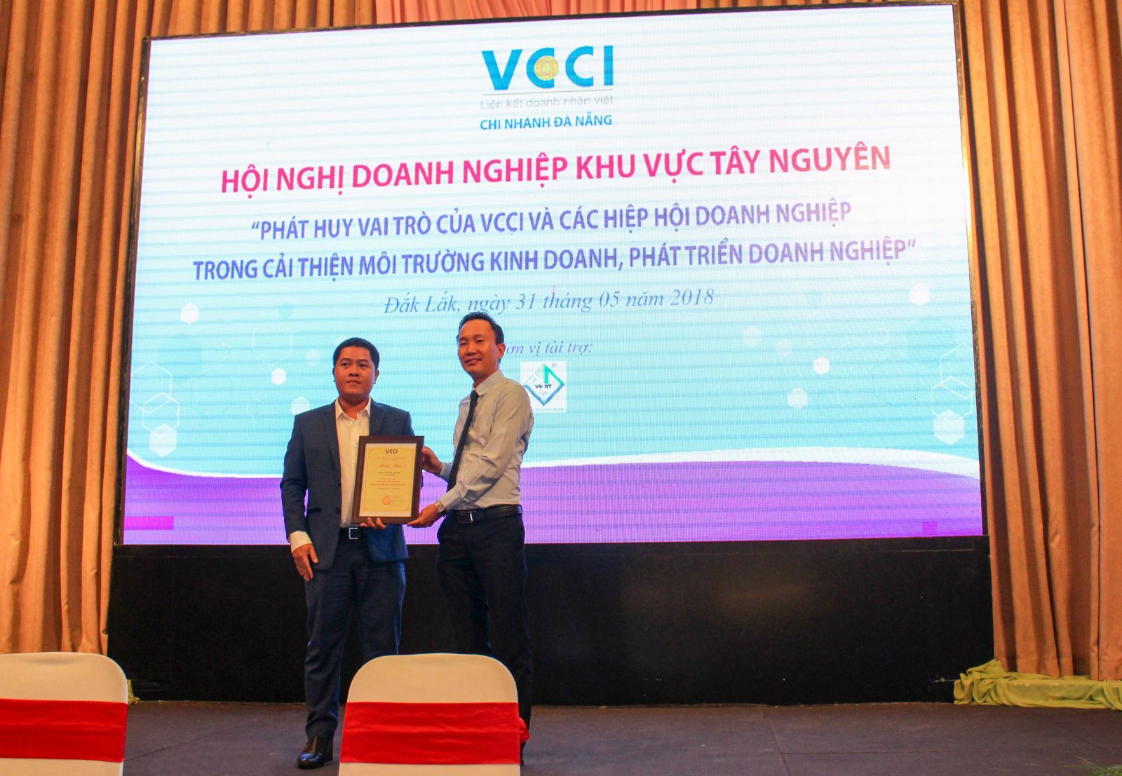 (Ông Nguyễn Tiến Quang - Giám đốc VCCI Đà Nẵng trao Chứng nhận đơn vị tài trợ cho ông Trần Văn Cường - Phó Tổng giám đốc VN Đà Thành Group)